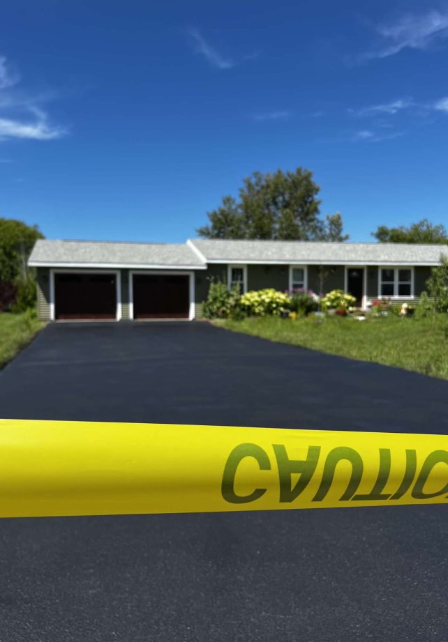 Freshly sealcoated driveway with caution tape